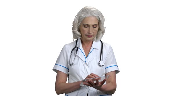 Mature Doctor Using Glass Tablet on White Background