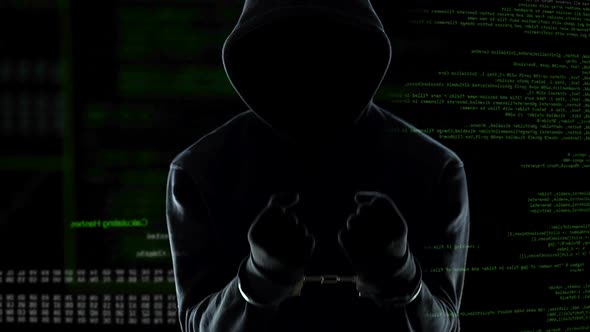 Silhouette of Handcuffed Anonymous Standing in Front of Animated Computer Code