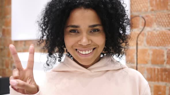 AfroAmerican Woman Gesturing Victory Sign Indoor