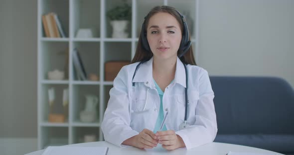 Professional Female Doctor Talking Looking at Camera Making Conference Video Call. Physician