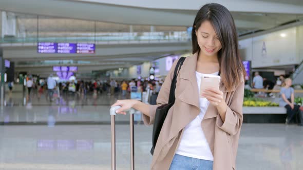 Travel woman using mobile phone in the airport