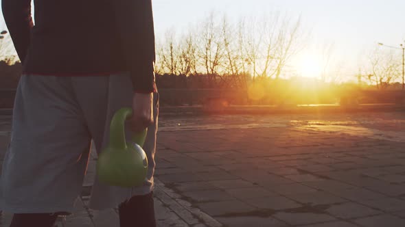 Young and fit man having evening workout outdoor. Urban sunset.