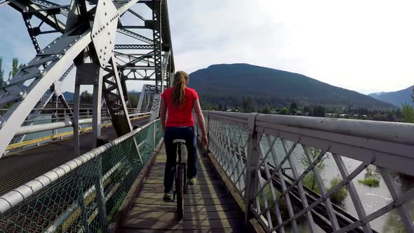 Woman riding unicycle on the bridge