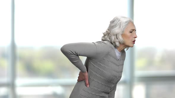 Old Thin Woman Suffering From a Back Pain