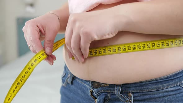 Closeup of Young Woman Loosing Weight Measuring Her Waist