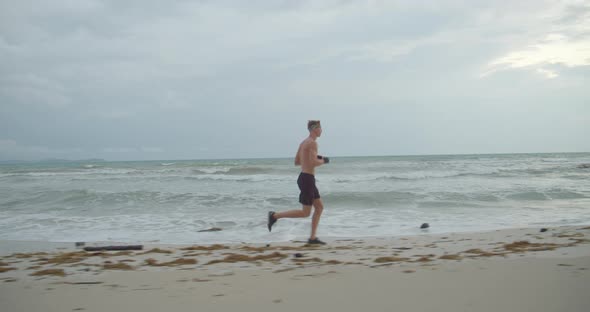 the Sportsman Worms Up Before Start To Train, He Runs on the Beach Early Morning