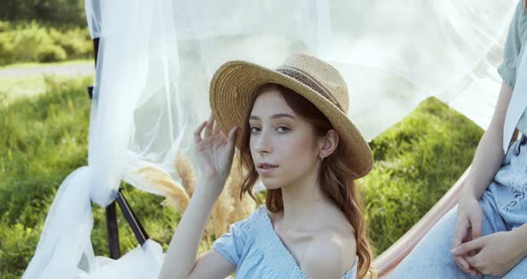 Close Up of Teen Girl in Straw Hat and Summer Clothes Posings on Green Field Landscape in