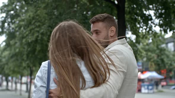 Couple Embracing and Discussing Something during Walk