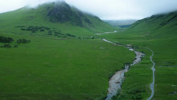 Drone shot pan up revealing country road to Glen Etive