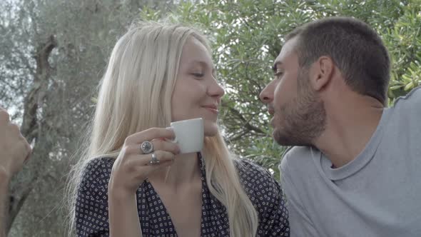 Romantic Couple of Happy Man and Woman in Love Smile and Kiss During Italian Breakfast in Natural