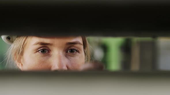 Caucasian woman's eyes looking through panels at factory