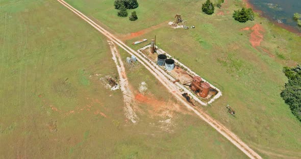 Pump Jack on the of Oilgas Pump Jack Out in Field Behind Oklahoma Prairie