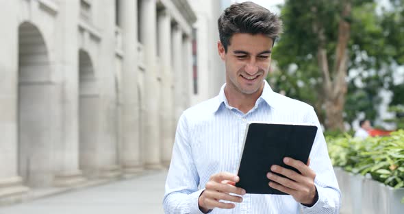 Hispanic Man Use of Digital Tablet Computer in City