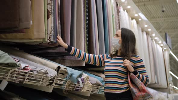 Female in Medical Mask Choosing Curtains in Store