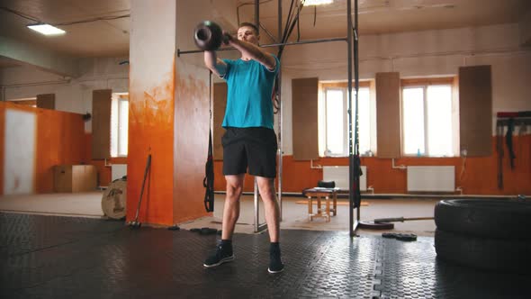 A Man Squatting with a Weight in His Hands