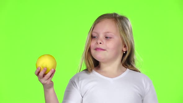 Little Girl Is Holding a Lemon and Sniffing It, Green Screen, Slow Motion