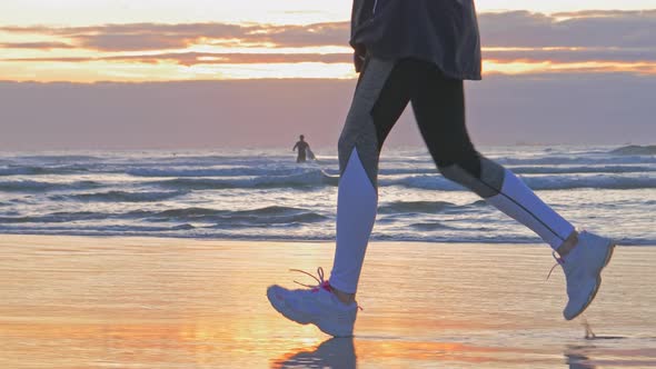 Woman Running on Sunset Beach Wet Sand Footprints