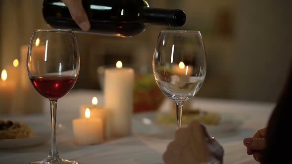 Caring Husband Pouring Wine in Wifes Glass, Couple Having Dinner Together