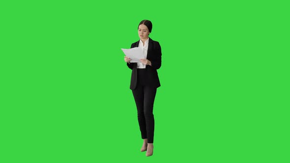 Serious Brunette Businesswoman Reading Documents on a Green Screen Chroma Key