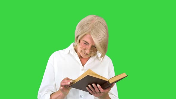 Senior Lady Woman Reading Old Book with Glasses on a Green Screen Chroma Key