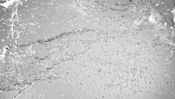 Super Slow Motion Shot of Side Water Splash on Grey Gradient Background at 1000Fps