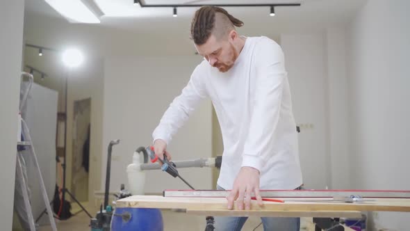 Carpenter Makes Measurements and Draws on Wood