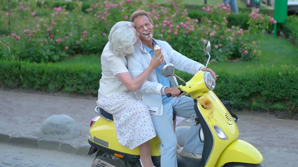 Mature Couple Sitting on Scooter