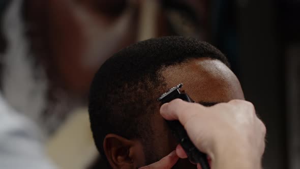 The Trimmer Cuts the Curled Hair of an African American  Macro Shot