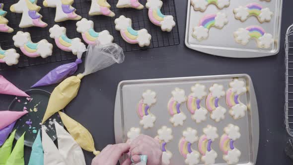 Step by step. Flat lay. Decorating unicorn theme sugar cookies with royal icing on baking sheet