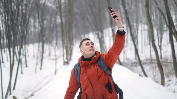 Man in Forest Searching for Mobile Signals