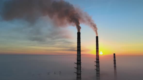 Aerial View of Coal Power Plant High Pipes with Black Smoke Moving Up Polluting Atmosphere at Sunset