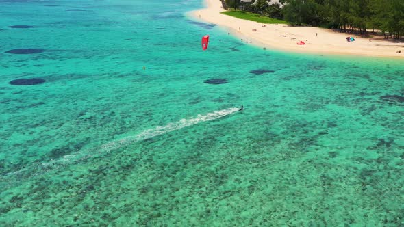 Kitesurfing Le Morne, Mauritius. Drone view flying backwards in front of kite surfer. Kite surfer su