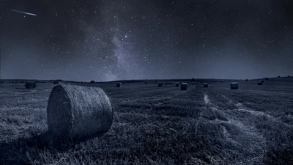 Milky way and field with hays at night, timelapse