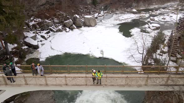 Tourists at the Bridge Above the Waterfall