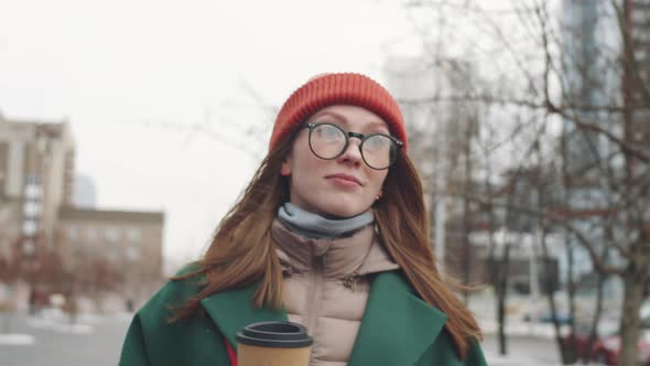 Young Woman Walking with To Go Coffee on Winter Day