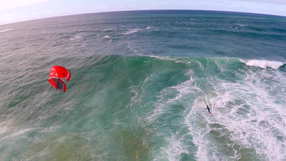 Aerial view of a man kitesurfing in Hawaii.