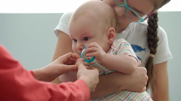 Teenager Girl Holding Baby with Toy