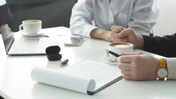 Closeup of Male and Female Hands on the Desk in the Office