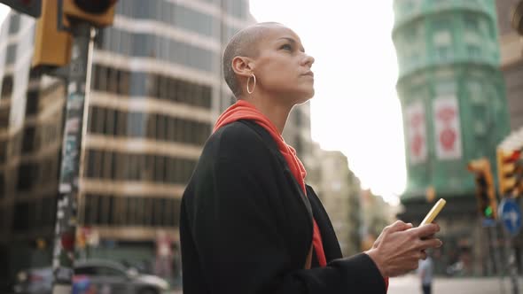 Serious bald woman looking at the map on phone