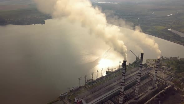Aerial view of high chimney pipes with grey smoke from coal power plant. Production of electricity