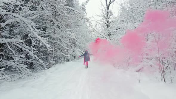 Woman in Pink Clothes Scarf and Hat Runs with Colored Smoke in Her Hands