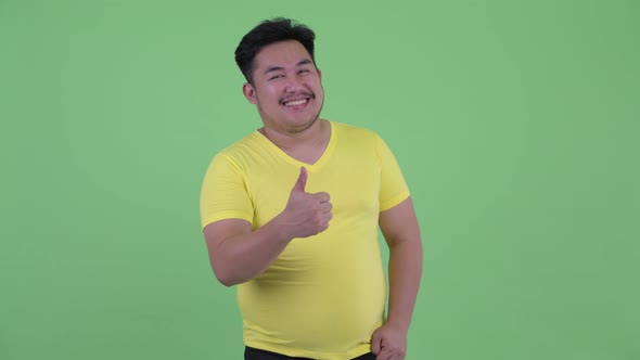 Happy Young Overweight Asian Man Giving Thumbs Up