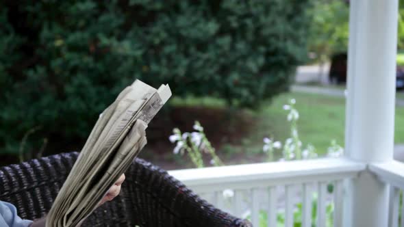 Senior man reading newspaper and drinking lemonade outdoors