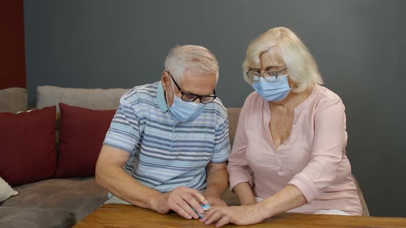 Senior Couple Grandfather and Grandmother Monitoring Oxygen Saturation with Digital Pulse Oximeter