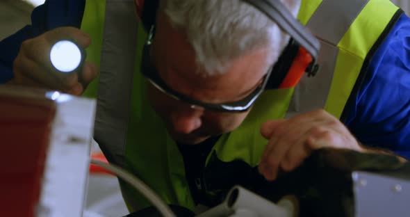 Engineer repairing aircraft engine in hangar 4k