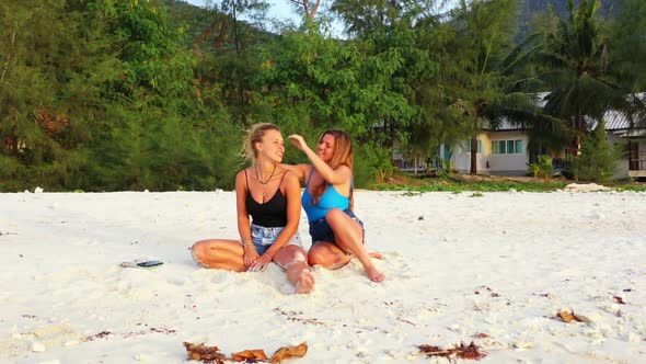 Beautiful women happy together on exotic resort beach holiday by blue ocean with white sandy backgro