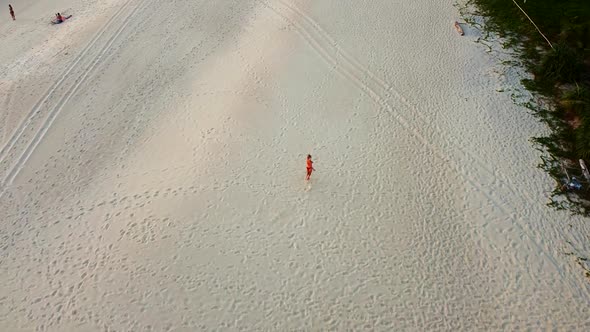 Young Woman In A Red Swimming Suite Happily Running On The Beach Barefoot, Phuket Thailand