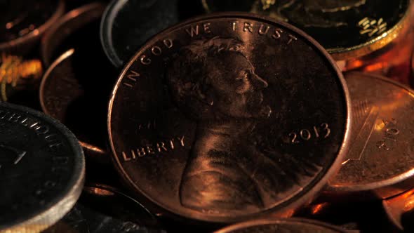 Coins in a Dark Room Shines From Them Falling on the Light. Close Up