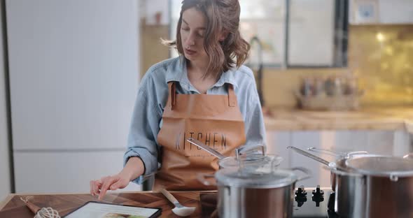 Woman with Digital Tablet While Cooking