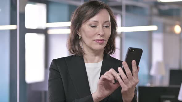 Portrait of Cheerful Middle Aged Businesswoman Using Smartphone